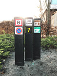 Verzwaarde bermpaal met twee bordjes honden aan de lijn